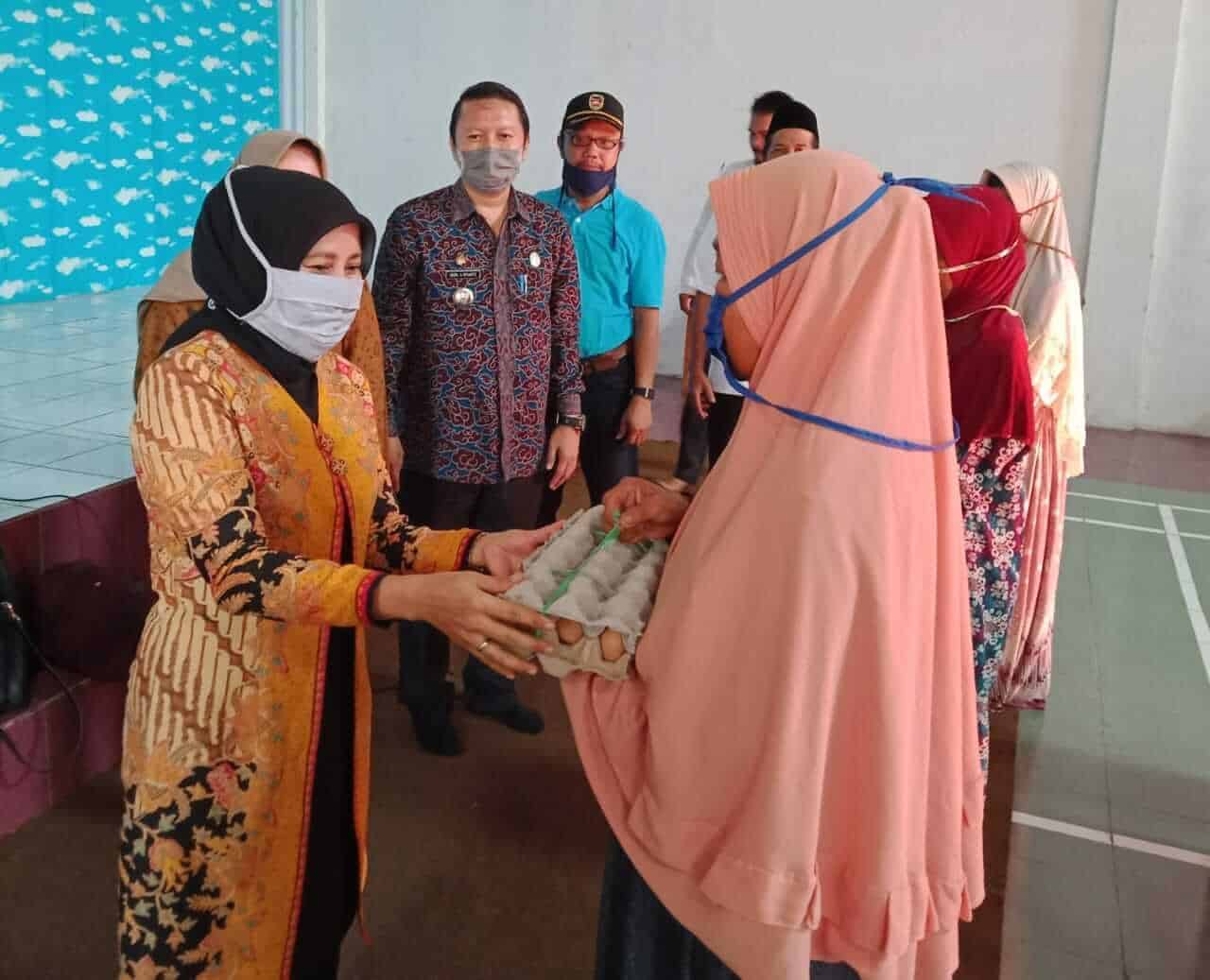 Camat Pondoksalam (pakai baju batik), Heru Agus Riyanto menyaksikan penyerahan bantuan Tali Asih ASN.
