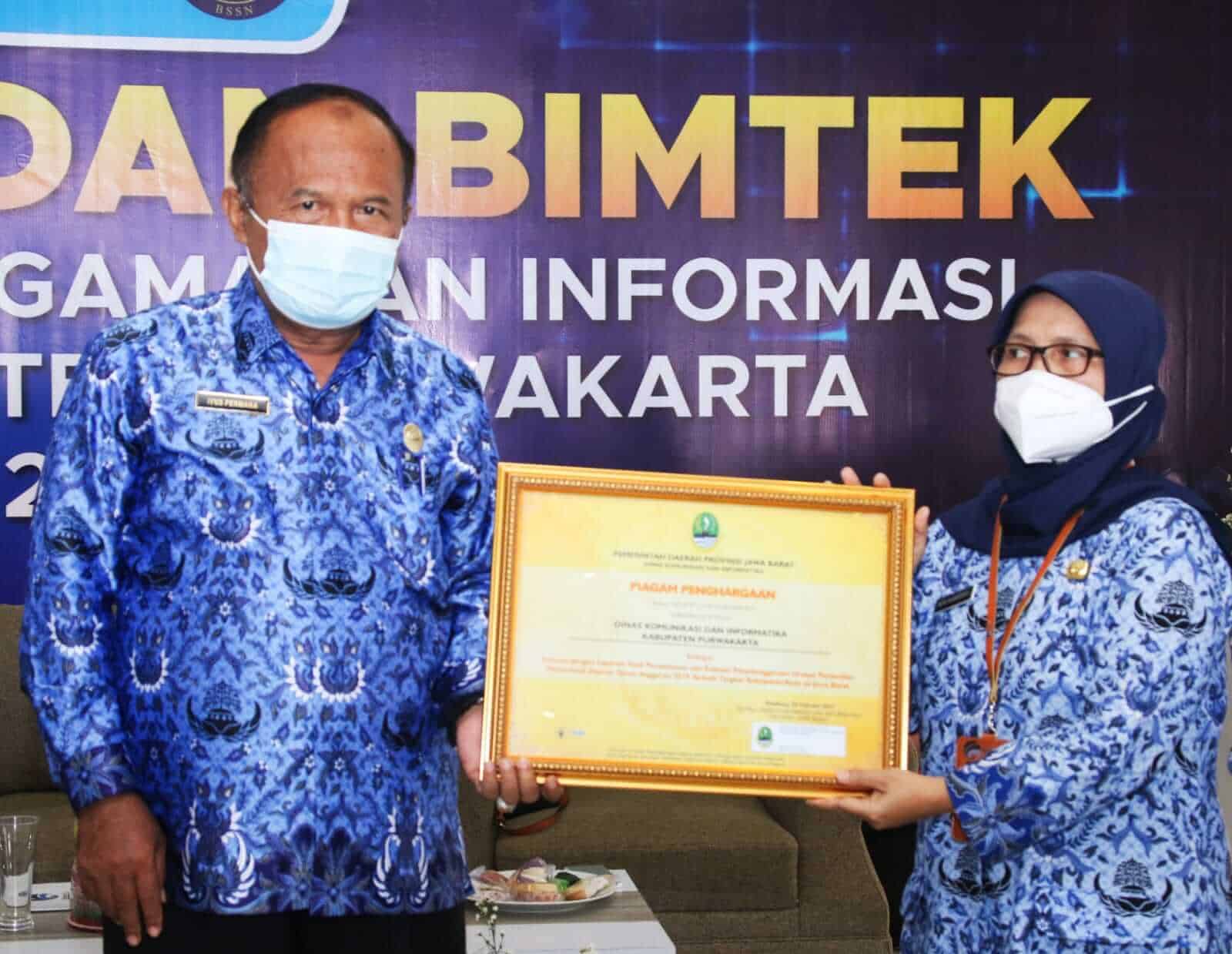 Sekda Purwakarta, H. Iyus Permana didampingi Kadis Kominfo, Siti Ida Hamidah saat menerima piagam penghargaan